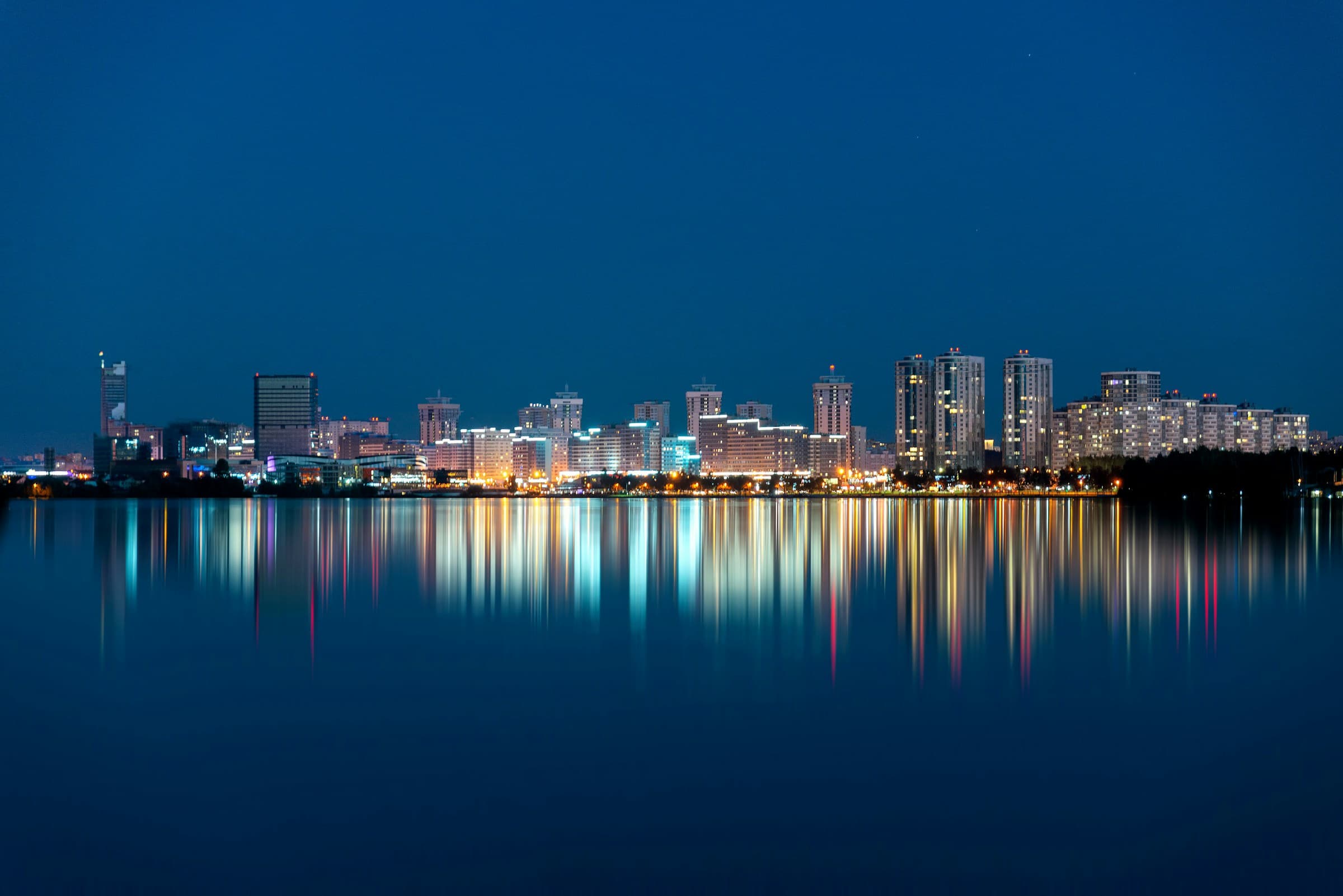 Minsk Belarus skyline glowing across the water at night